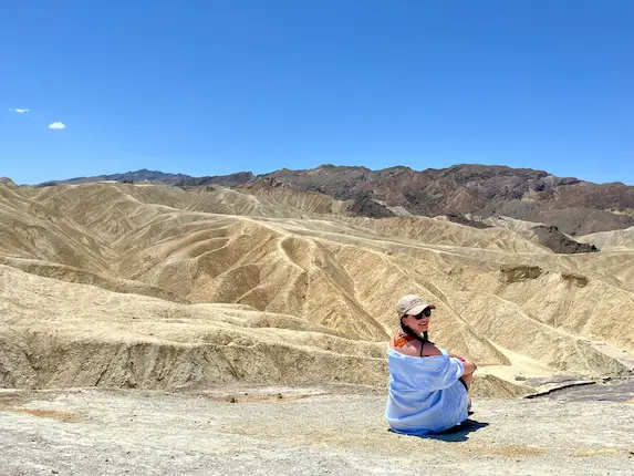 Carol observando vilarejo entre montanhas em uma viagem